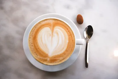 Café com leite e um coração em camadas desenhado na espuma