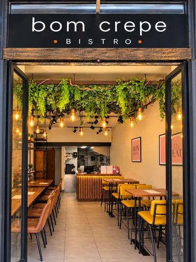 A entrada do Bom Crepe Bistro, com o letreiro e as portas abertas para o interior